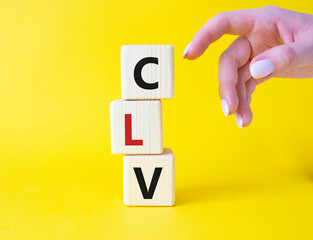 CLV - Customer Lifetime Value symbol. Concept word CLV on wooden cubes. Businessman hand. Beautiful...