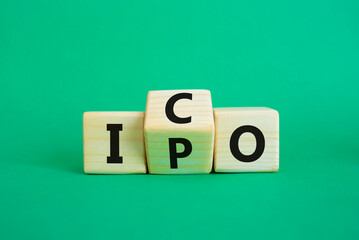 ICO and IPO symbol. Wooden cubes with words ICO - initial coin offering and IPO - initial public offering. Beautiful green background. Business concept. Copy space