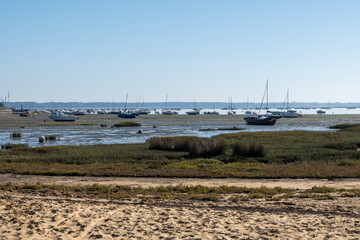 View on Arcachon Bay at low tide with many fisherman's boats and oysters farms, Cap Ferret...
