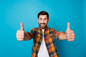Portrait of toothy beaming pleasant guy with stubble wear checkered shirt showing thumbs up to you...