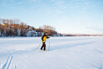 A skier walks on the snow making his way in snowdrifts, a solo workout in the countryside, a man on skis.