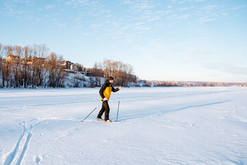 A skier walks on the snow making his way in snowdrifts, a solo workout in the countryside, a man on...