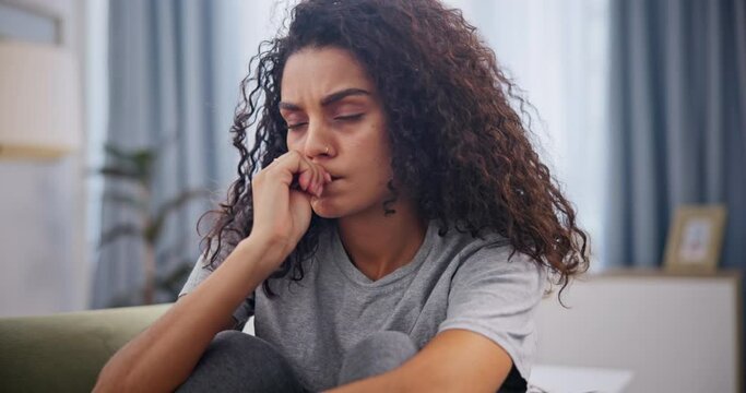 Woman, biting nails and mental health on couch in home with schizophrenia, frustrated and addiction. Psychology, person and anxiety with trauma, psychosis and suffering on sofa in lounge with stress
