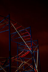 Roller coaster at night in winter, red rails