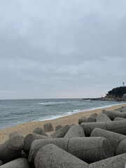 A sandy beach, gloomy weather, large stones, seashore