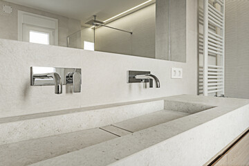 A synthetic stone sink in a modern design bathroom with chrome taps and a large niche in the wall...