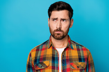 Portrait of offended upset gloomy disappointed guy with stubble wear checkered shirt look empty space isolated on blue color background