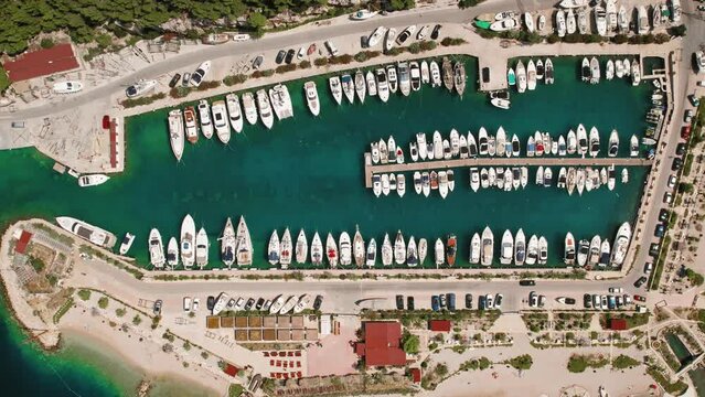 Sailing Vessels docked in harbor. Aerial view of marina brimming with boats ready for sea voyages in sunny summer day.