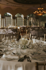 
Salón de celebraciones repleto de mesas decoradas en tonos blancos y sillas doradas. Mesas...