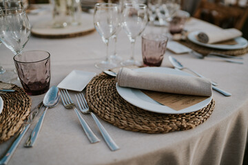 
Banquete al aire libre. Mesa redonda decorada en tonos ocres y rosas. Vajilla de porcelana,...