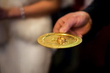 Gold plate is held by priest during wedding ceremony