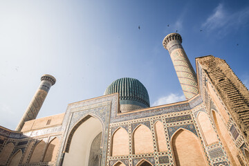 Facade of the Gur Emir mausoleum with mosaic brick walls in the ancient city of Samarkand in...
