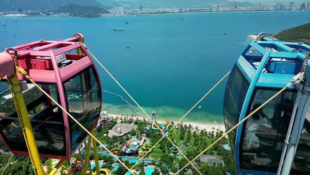 Vietnam, Nha Trang, Vinpearl. Side view of the ferris wheel cabin on Vinpearl Island with Mt. in the background. A ride on a carousel in an amusement park with the sunrise in the background. 4K
