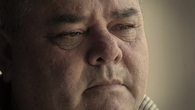 close up portrait of a fat man standing sad and pensive near the window