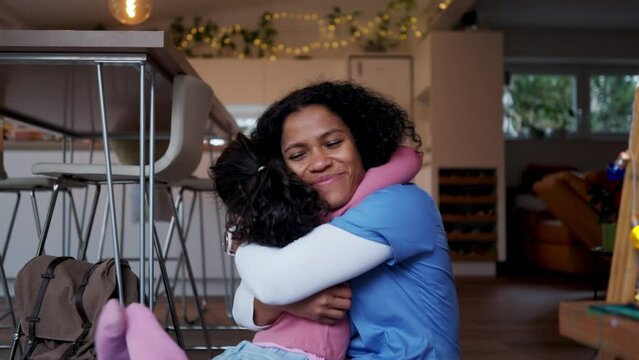 Nurse, doctor returning home from work, scolding her little daughter, explaining her something. Lifestyle of healthcare worker as parent.