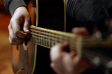 Close up of male's hands playing acoustic guitar.