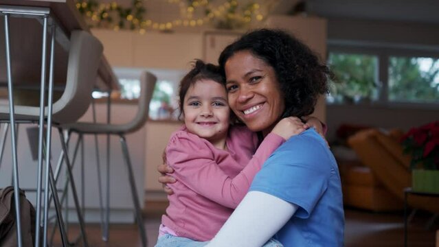 Video of nurse and her little daughter hugging at home, after work. Lifestyle of healthcare worker as parent.
