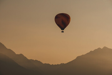 hot air orange balloon in flight over beautiful clear morning sky