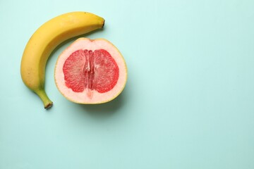 Banana and half of grapefruit on turquoise background, flat lay with space for text. Sex concept
