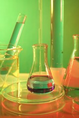 Laboratory analysis. Different glassware on table against color background, closeup