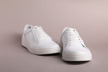 Fototapeta na wymiar Pair of stylish white sneakers on grey background