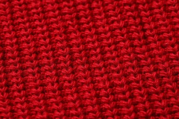 Texture of soft red knitted fabric as background, top view