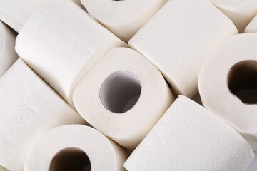 Many soft toilet paper rolls as background, above view