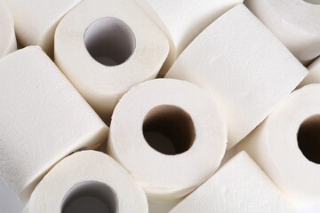 Many soft toilet paper rolls as background, above view