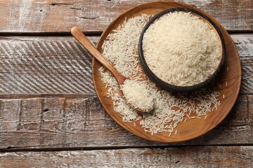 Raw basmati rice on wooden table, top view. Space for text