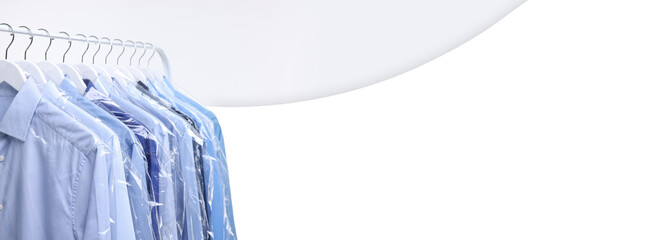 Dry-cleaning service. Different clothes in plastic bags hanging on rack against white background,...