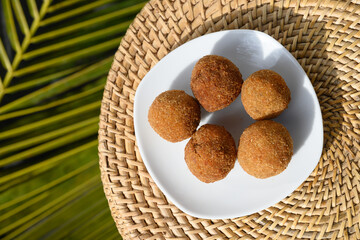 Authentic Sri Lankan cutlets snack street foods, short eats in white plate made with tuna, potatoes, onion and deep fried on palm leaf. Local food. Top view, copy space.