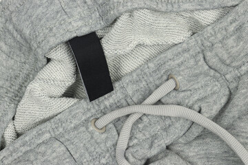 Grey tracksuit joggers sweatpants with black label tag close-up
