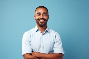 happy african american man with crossed arms looking at camera over blue background