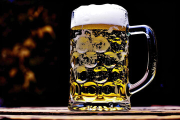 Glass of beer sitting on top of wooden table. Suitable for bar and restaurant promotions