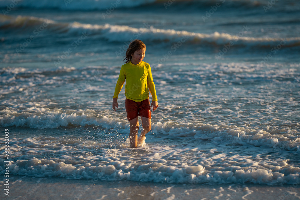 Wall mural excited kid playing in splashing water on summer sea. summer vacation. kid play of waves at sea. lit