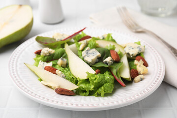 Delicious pear salad on white tiled table, closeup