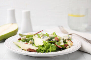 Delicious pear salad on white tiled table, closeup