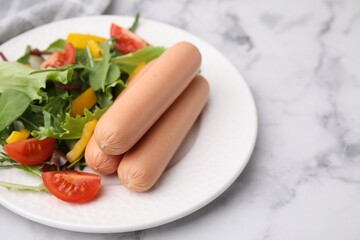 Delicious boiled sausages with salad on white marble table, closeup