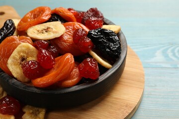 Mix of delicious dried fruits on light blue wooden table, closeup
