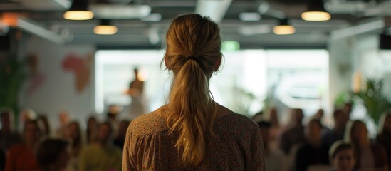 Rear view of a startup woman leader speaking during a pitch session.