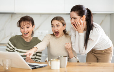 Women are sitting at computer and are immensely happy, exclaim joyfully and are fortunate to...