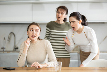 Woman sits at kitchen table and listens to abuse and swearing of her sisters. Female friends express dissatisfaction with their fellow, unpleasant conversation. - obrazy, fototapety, plakaty