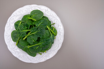 Fresh green baby Spinach leaves, diet and health concept, weight loss, spinach on ceramic plate,...