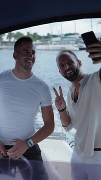 A couple of caucasian adult men taking a selfie in a boat