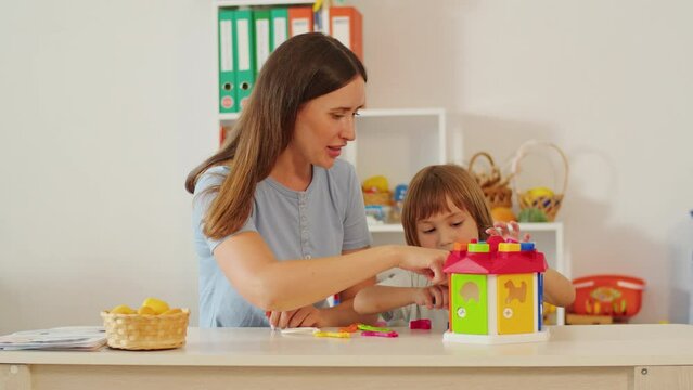 Mother and child playing with shape sorter toy at home. Family bonding and early education concept for design and print.
