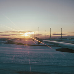 Sunset dusk shining on a snowy landing airport track seen from an airplane window