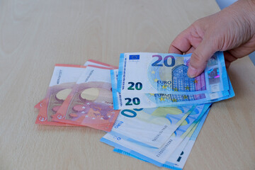 female hands close-up counting paper 10, 20 euro banknotes, concept cash, payments, savings,...
