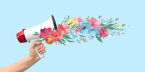 Female hand with megaphone and drawn flowers on light blue background