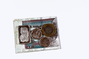 Two British sterling pounds coin, Egyptian pounds cash money with silver precious metal ounce bar...