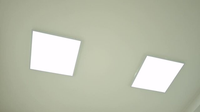Two led panels on ceiling, turning on and off light in the modern minimalist room. Video of switching on and then off light